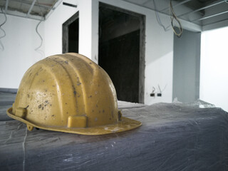 put the safety helmet on the table, yellow helmet is dirty, photo is depth of field style