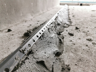 PVC Corner Bead installed on mortar, Self leveling concrete being applied to a  floor, photo is...