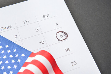 Calendar with marked date of National Day of Prayer and Remembrance for the Victims of the Terrorist Attacks and USA flag on dark background