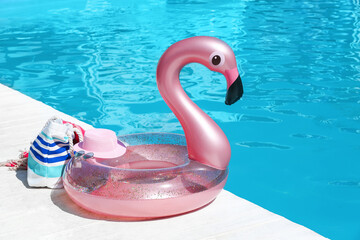 Inflatable ring and beach accessories on edge of swimming pool