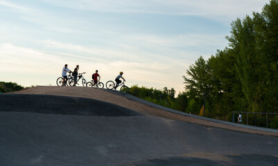 Kazakhstan, Nur-Sultan, July 2021. Teenagers prepare to ride their bicycles on a wave springboard...