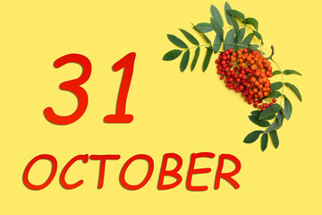 Rowan branch with red and orange berries and green leaves and date of 31 october on a yellow background.