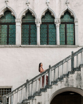 Side View Of Stylish Young Woman Walking On Stairs Of Beautiful Old Building In City