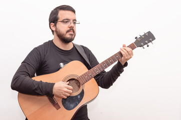 white adult Hispanic Latino male with beard and lens posing with his acoustic guitar with pensive face on white background