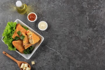 Asian Food. Vegetarian Samsa (Samosas) in Triangle Shape with Tomato Sauce and Mayonaise. Popular in Indonesia as Risoles  Sayur. Dark Grey Cement Background Copy Space Top View
