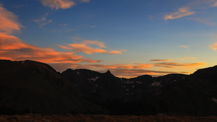Rocky mountain peaks with colorful sky after sunset