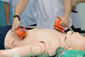mannequin dummy during medical training to control of the defibrillate dummy. concept of saving lives