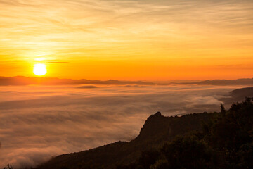 sunrise or sunset with mist and mountain. Orange sky.