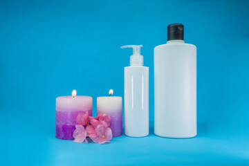 Close up template of spa cosmetic products on blue background, with candles. Minimal concept. Showcase for presentation skincare products