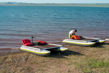 Electric catamarans by the lake with red seats.