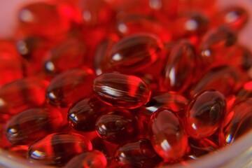  Krill oil capsules background.omega fatty acids.Red capsules with krill oil. Natural supplements...