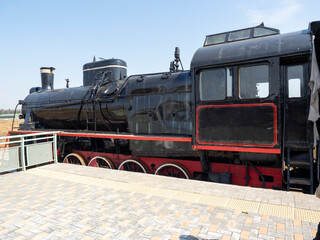 Obraz premium An old vintage black steam locomotive is standing on the platform. Old technologies