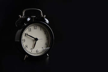 Alarm clock on a black background.