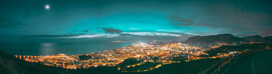 Fototapeta premium Terracina, Italy. Top View Skyline Cityscape City In Evening Night Illuminations. Panorama, Panoramic View