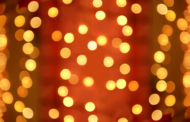 Abstract holiday bokeh background. Blurred lights of garland hanging on Christmas tree. 