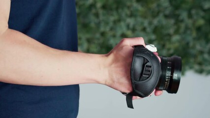 Videographer Filming Video Using DSLR Camera With Hand Strap. close up, side view
