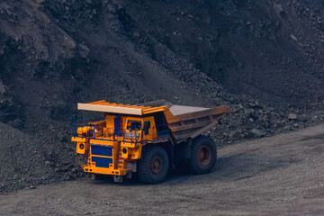 Huge empty dump truck on a gravel road in iron ore quarry