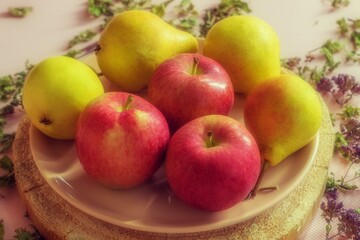 Four ripe pears and three red juicy apples are in the plate