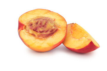 A half of ripe nectarine with a bone next to a quarter of nectarine isolated on a white background