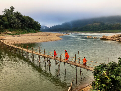 Wooden bridge on a river with people on it