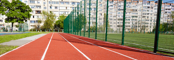 Fototapeta premium Red treadmill on sport field. Running track on the stadium