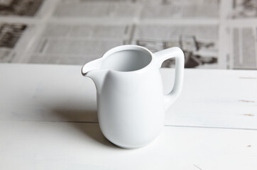 Empty milk jug on wooden background. Porcelain sauce boat, pitcher, creamer or ceramic gravy boat