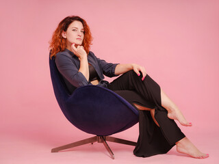woman in casual dark shirt isolated on pastel pink color background studio portrait. People...