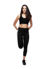 Fototapeta premium Young woman in black sportswear practices yoga. Sports and active lifestyle. Full height. Isolated on white background. Vertical.