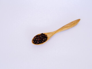 black pepper on wooden spoon