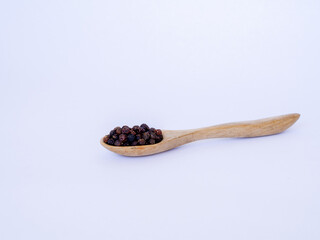black pepper on wooden spoon