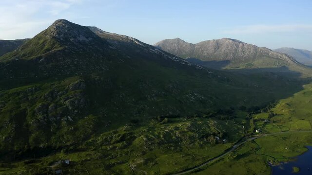Twelve Bens Mountains, Recess, Connemara, County Galway, Ireland, July 2021. Drone slowly tracks west over Ballynahinch Lake, while ascending and looking north into the Garraun mountain complex.