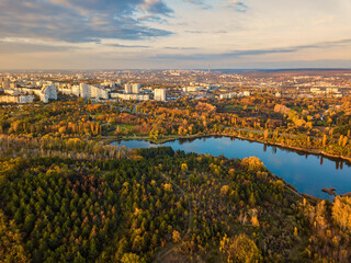 Aerial view of a lake in a park with autumn trees. Kishinev, Moldova. Epic aerial flight over water. Colorful autumn trees in the daytime.