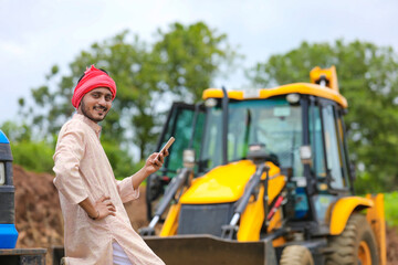 Indian farmer using smartphone at his field