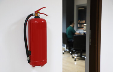 fire extinguisher hanging on office wall, fire extinguisher near door