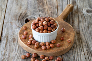 Organic hazelnut. Hazelnut on wood background. Bulk hazelnut kernels. Hazelnut on a ceramic plate