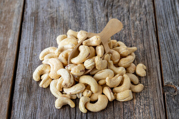 Roasted Cashew snack. Cashew on wooden spoon. Bulk Cashew nut kernels.