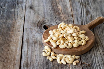 Roasted Cashews. Cashew nuts on wood background. Bulk Cashews. Copy space