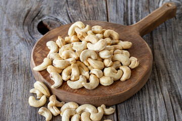 Roasted Cashews. Cashew nuts on wood background. Bulk Cashews.