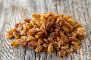 Raisins. Dry raisins on wood floor. Bulk Raisins grains