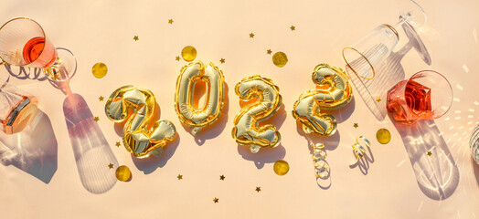 Gold balloons 2022, champagne glasses Concept fun New Years party