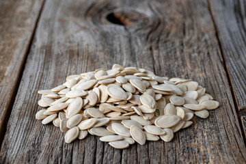 Shelled Pumpkin seeds. Pumpkin seeds on wood background. Bulk Pumpkin Seed Grains