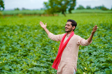 Young Indian farmer at green agriculture field.