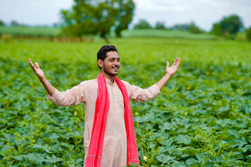 Young Indian farmer at green agriculture field.