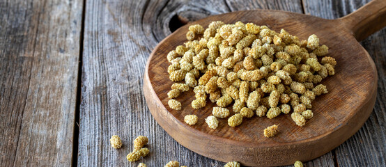 Dried mulberry. Dried mulberry nuts on wood background. Bulk dried mulberry grains. Copy space