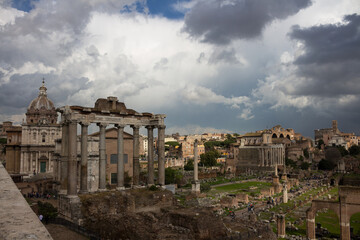 Fototapeta na wymiar Top view of the Roman Forum against a dramatic sky. Ancient architecture and the urban landscape of historical Rome.