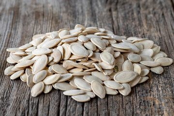 Shelled Pumpkin seeds. Pumpkin seeds on wood background. Bulk Pumpkin Seeds.