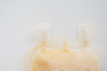 Close up scientist hand holding fresh frozen plasma bag in storage blood refrigerator at blood bank...