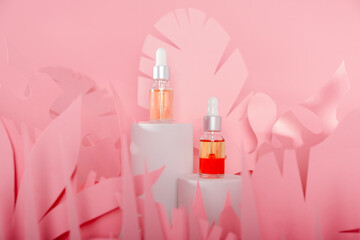 Dropper glass bottles with pipette standing on a white podium. Transparent hyaluronic natural beauty mineral product and eco serum skin care concept.