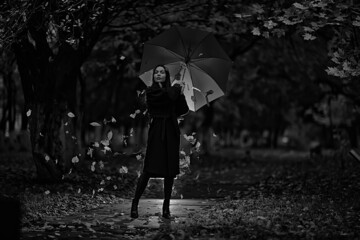 autumn evening woman holds umbrella, october in dark city park, young lonely model with umbrella