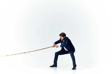 a man in a suit pulls the rope career office light background